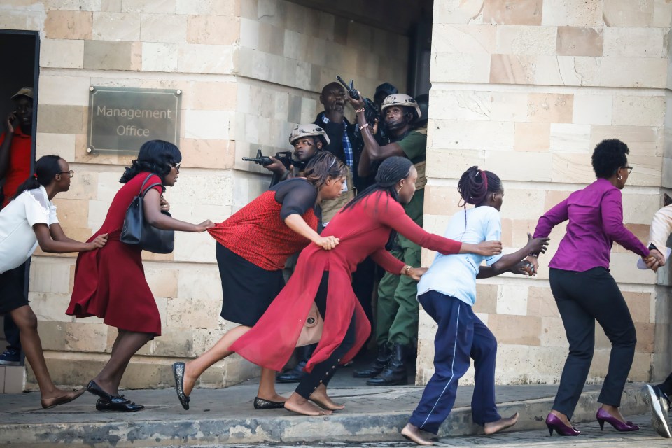Women are evacuated out of the scene as security officers search for attackers during an attack on a hotel in Nairobi, Kenya