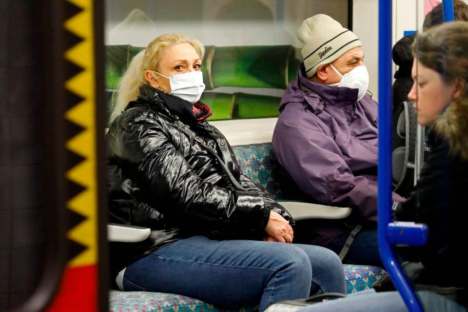 People wear masks on the Tube in London
