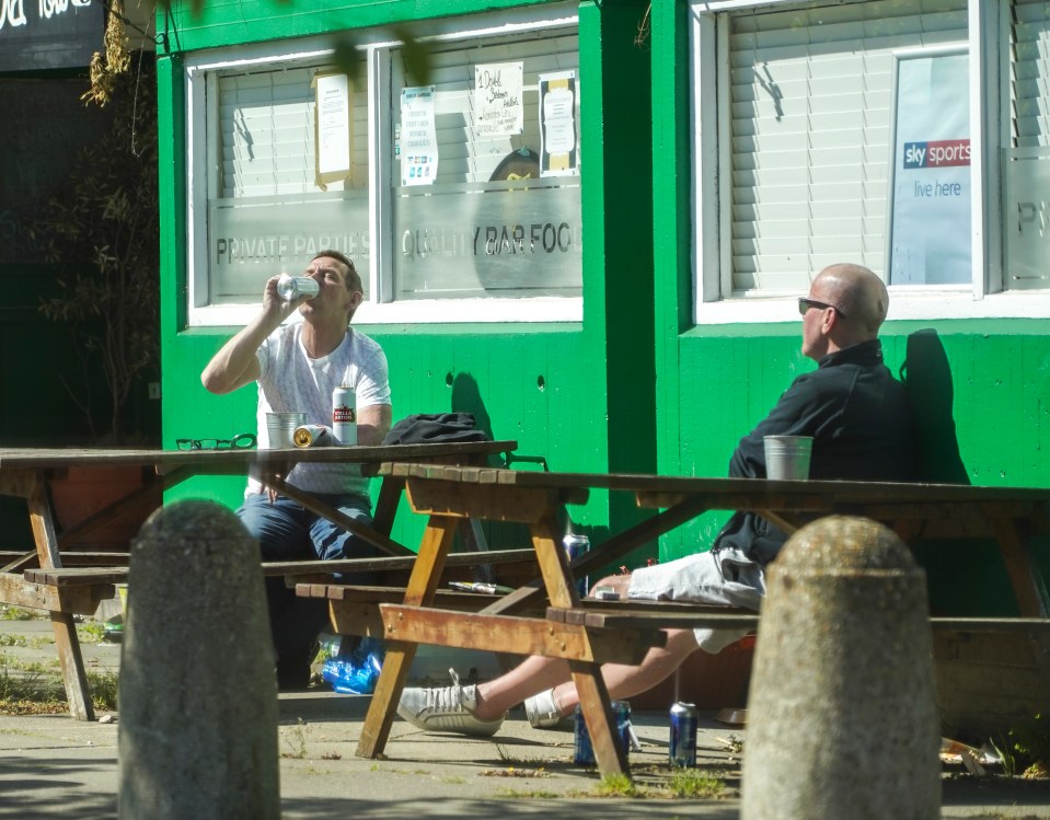  Two men drink cans of beer outside a boozer in South London despite pub closures