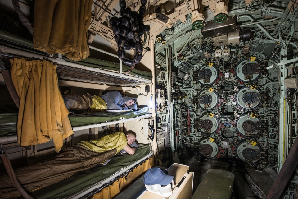  Thissen and a companion try the beds in a ship's sleeping quarters