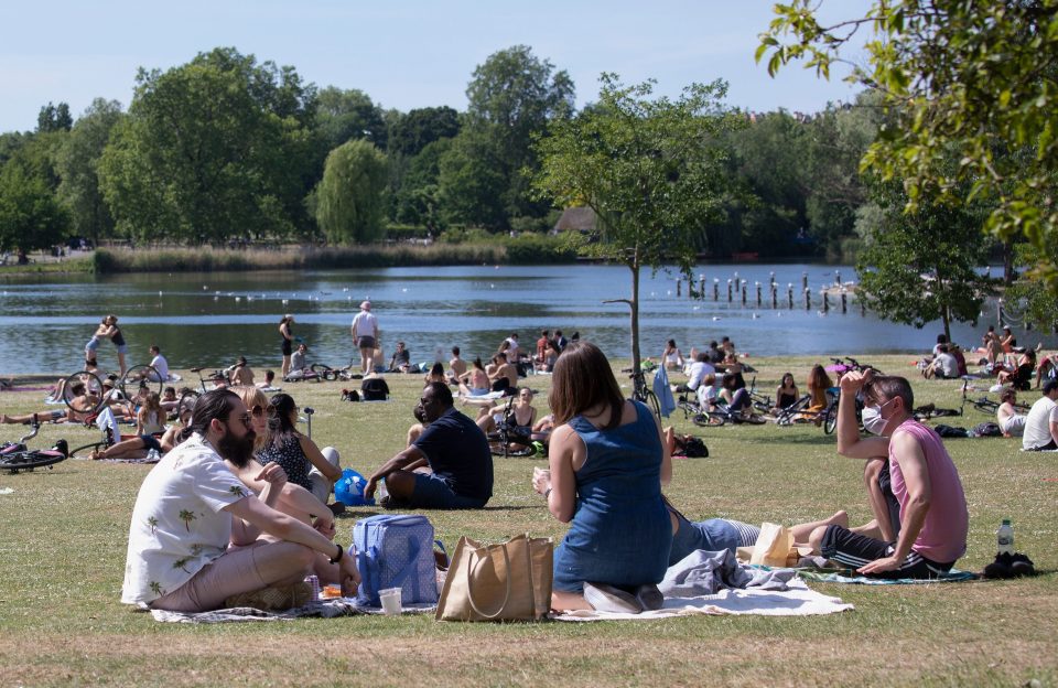 Members of the public sunbathing by the lake on a sunny Bank Holiday Monday in Regents Park on May 25, 2020 in London, England