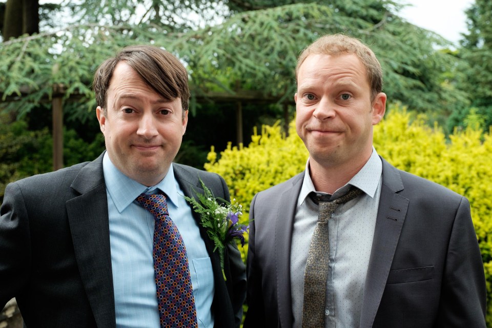 two men in suits and ties are posing for a picture