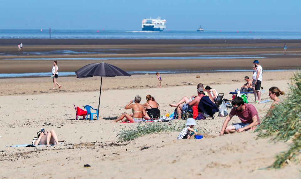 People relax on Crosby Beach today as Britain is braced for a mini June heatwave