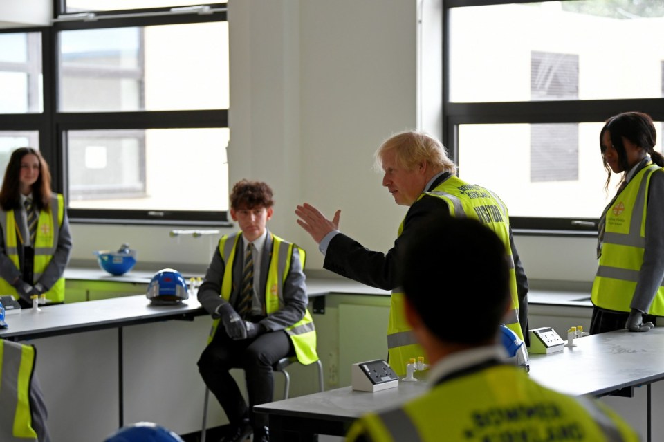 Boris Johnson speaks with year-ten pupils in a science room under construction at Ealing Fields High School, in west London