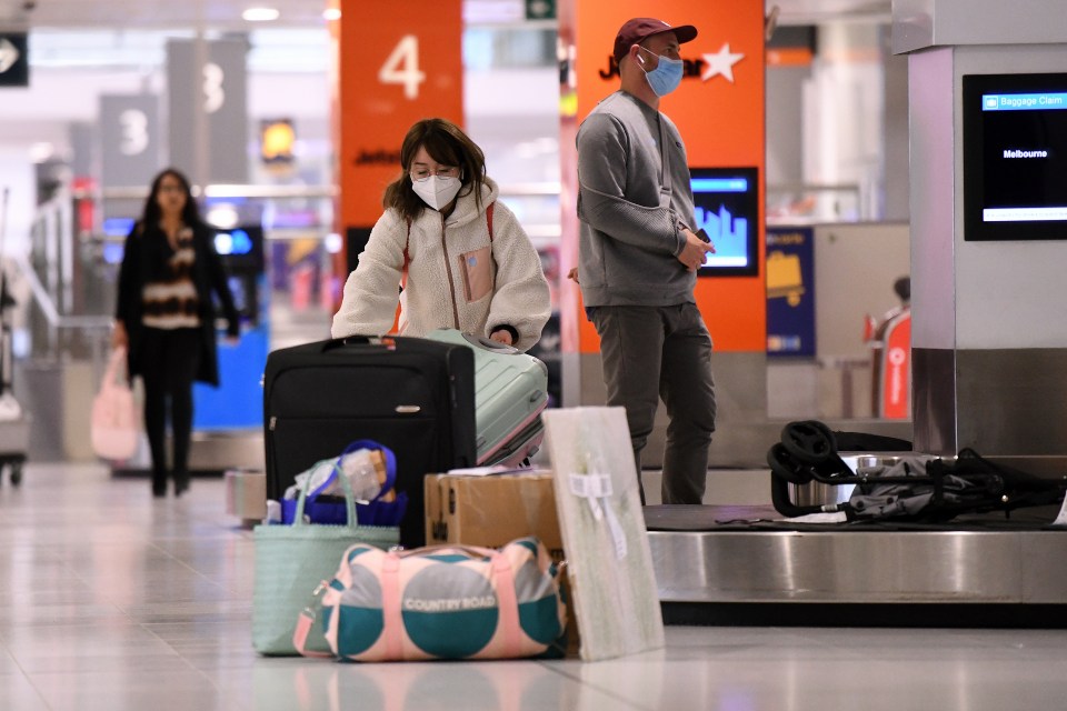 A woman collecting her bags at Sydney airport