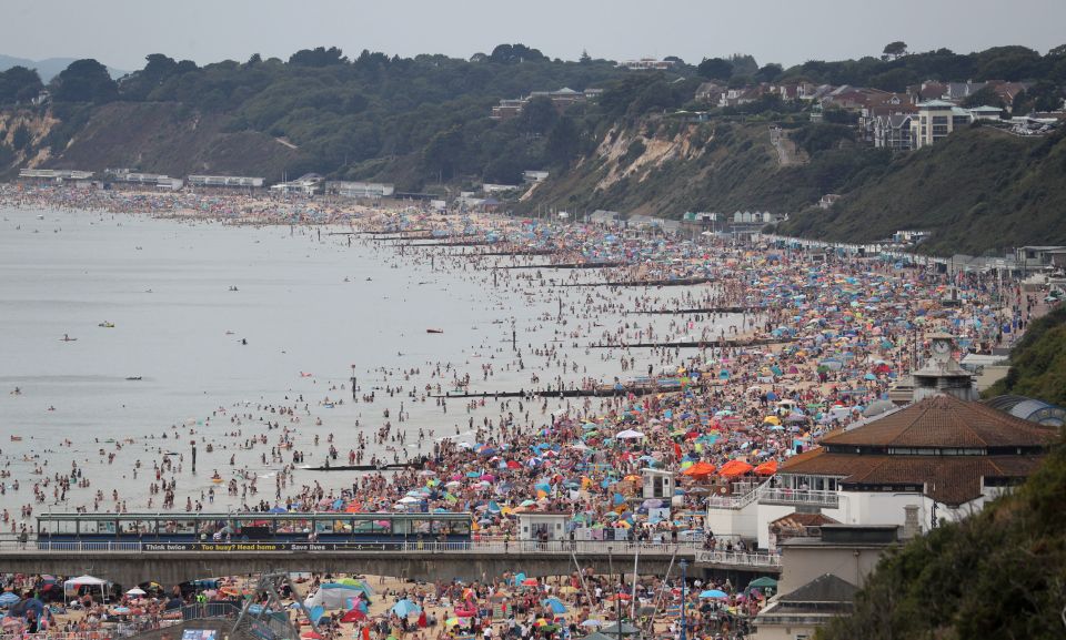 This photo, taken from a clifftop overlooking the beach at Bournemouth and looking towards Poole, shows the coastline is busy for miles