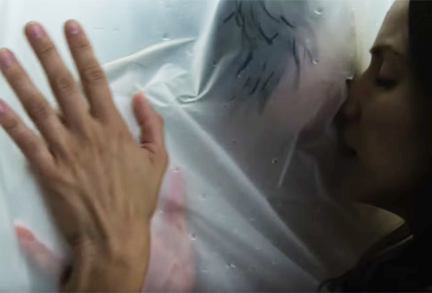 The pair touch each other and kiss through the waterproof fabric 