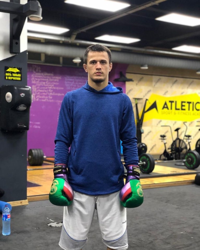 Usman Nurmagomedov in boxing gloves at a gym.