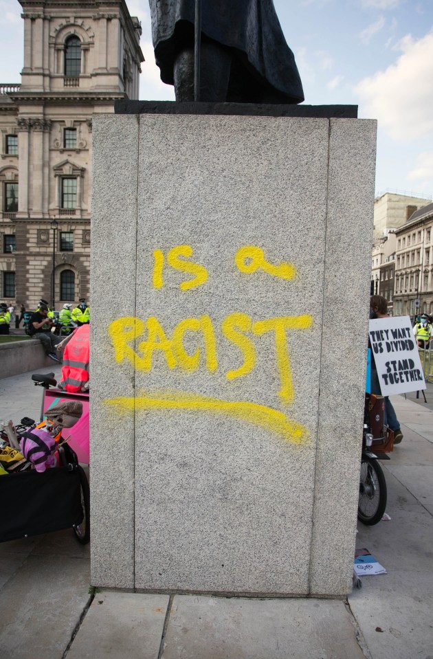 The yobs spray-painted 'is a racist' under the former PM's statue