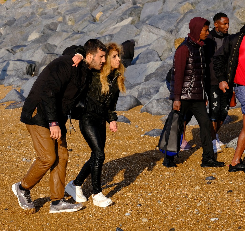 A man and a woman hold on to each other for support after crossing the Channel