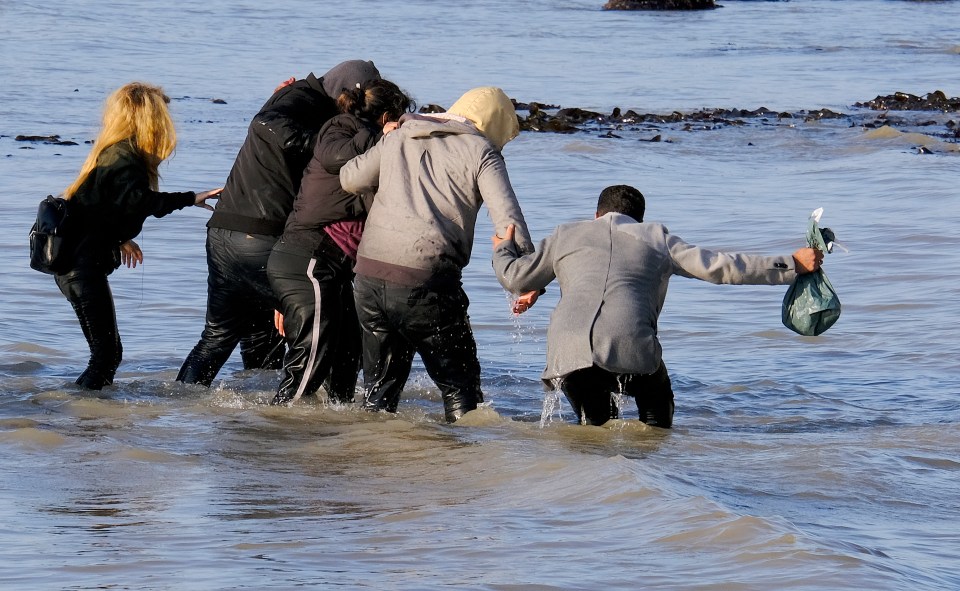 The group held on to each other as they walked towards the shore