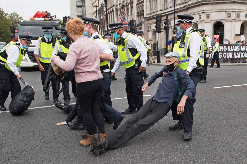 Police remove an Extinction Rebellion protester from the road by Parliament Square 