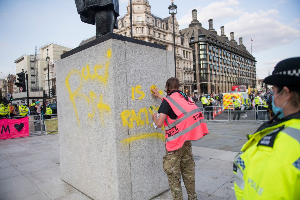 A man attempting to remove the graffiti