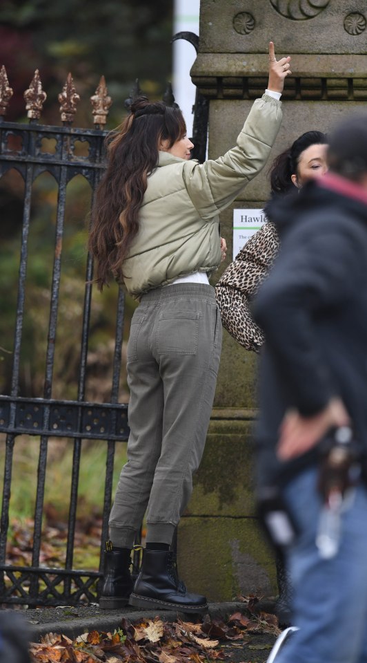Michelle wore grey trousers, chunky boots and a green bomber jacket as she filmed her scenes 