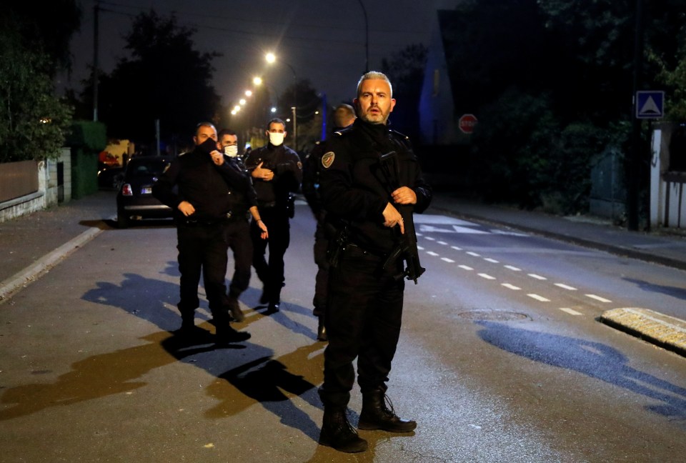 Armed cops stand guard on Friday night in the French suburb
