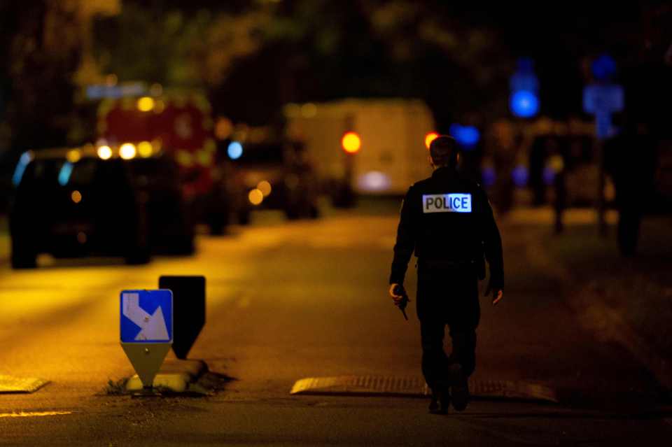 A French police officer stands guard on a street in Eragny