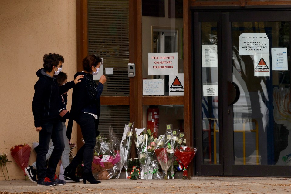 A mourner is comforted outside of the school today
