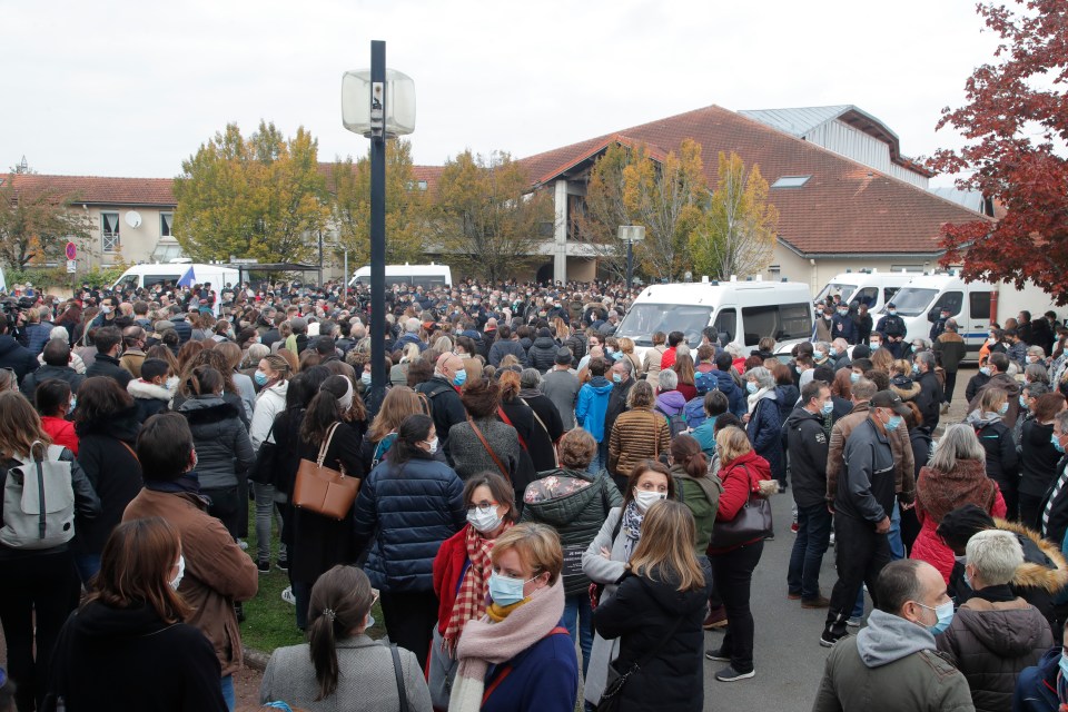 A crowd gathers outside the school in the Paris suburbs