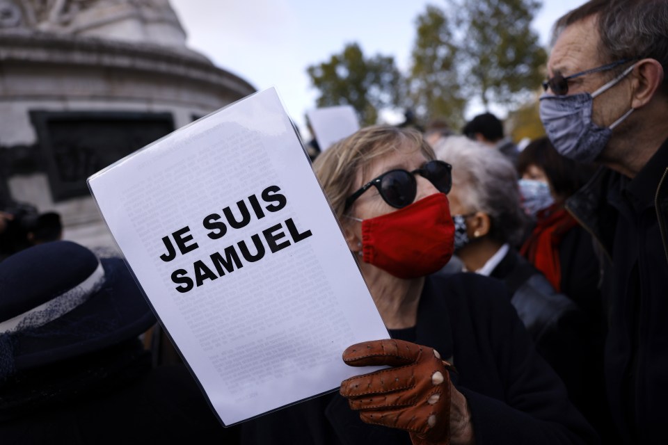 A woman holds a sign which reads 'I am Samuel'