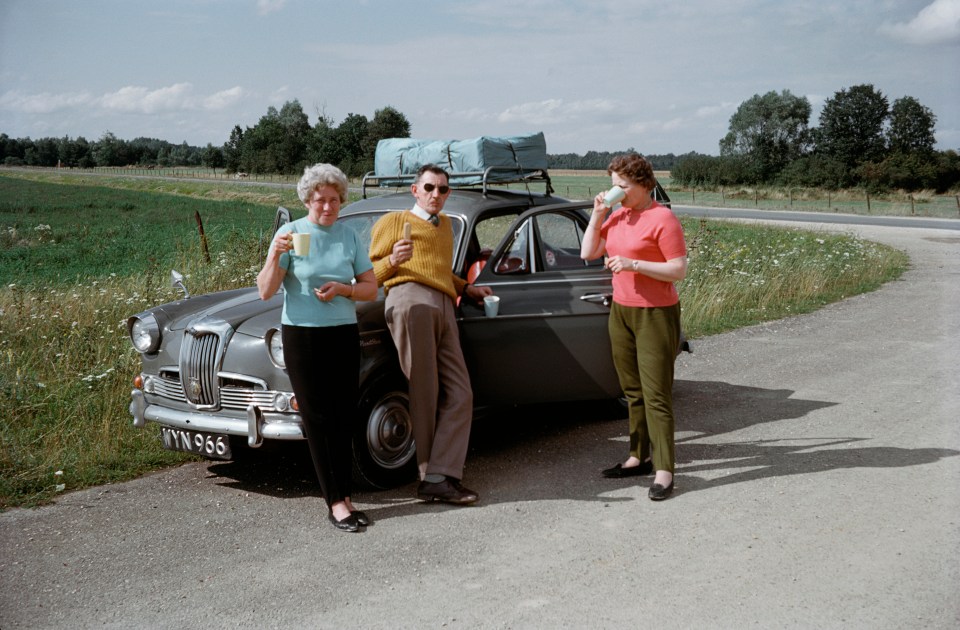 This brightly dressed trio pulled over on the side of the road to enjoy a tea break on the go in 1961