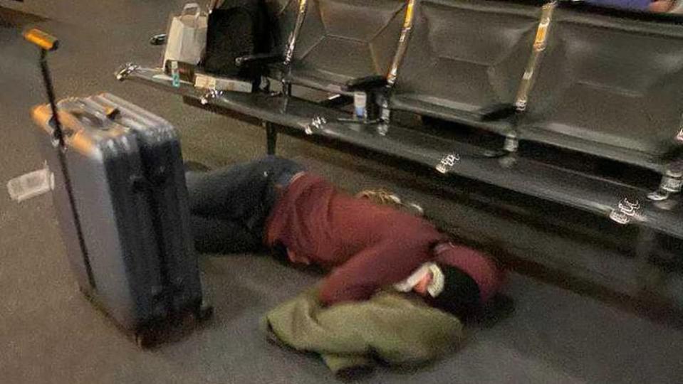 One of the passengers sleeping on the floor of the airport 