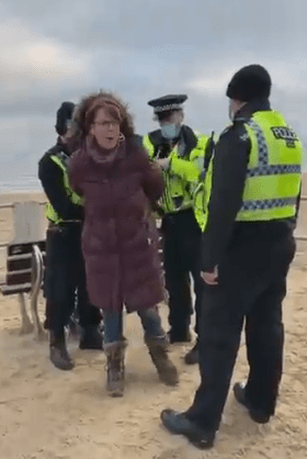 One woman was placed in handcuffs for "sitting on a bench" - but it was staged, according to police