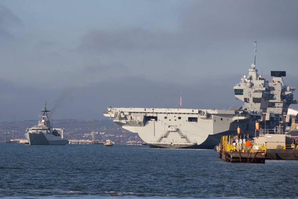 HMS Tyne, left, passes HMS Prince Of Wales as it heads to the Channel fishing grounds on New Year's Eve