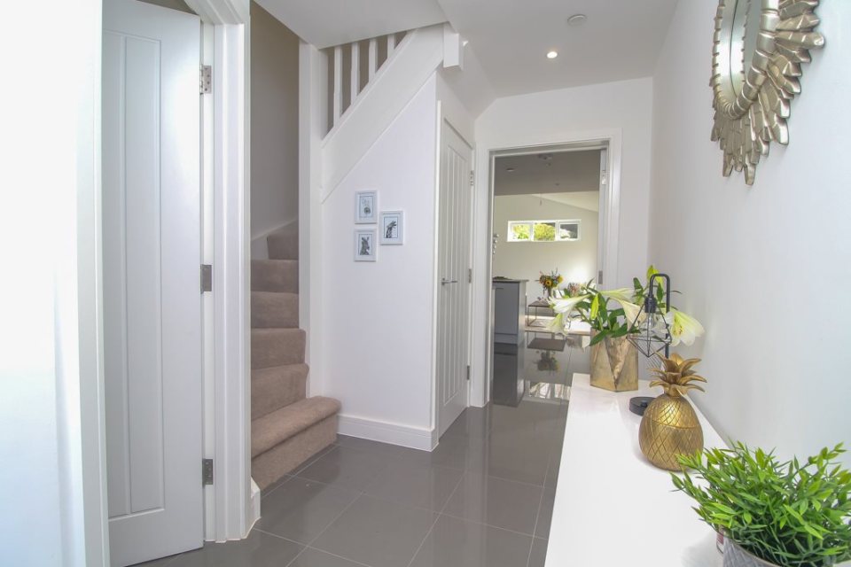 The slimline newly-built property has been slotted into a strip of land next to a footbridge 