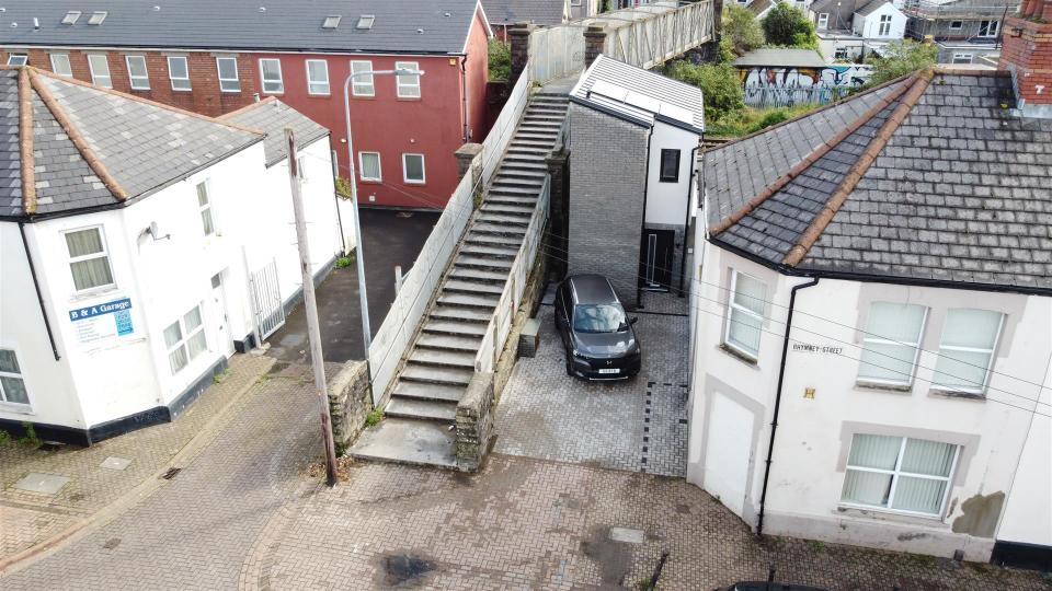 The detached house can be seen next to a regular sized home 