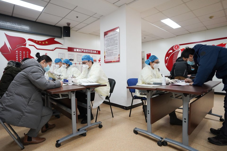 Medical workers in China get people to sign consent forms for Covid-19 jabs