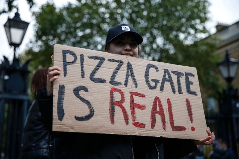 A protestor holds a QAnon-linked sign during a Save The Children rally outside Downing Street on October 10, 2020