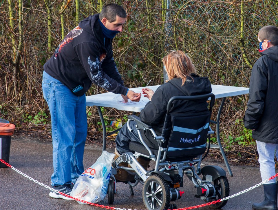 All residents over the age of 18 have been asked to get a test. People are pictured signing up today in Broxbourne