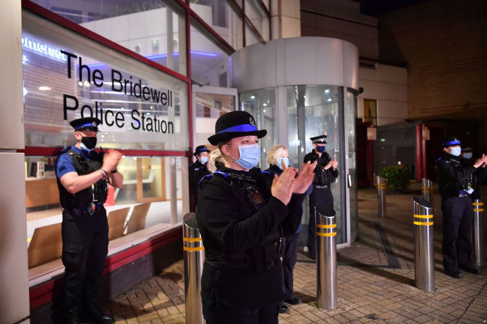 Police officers outside the Bridewell police station in Bristol city centre clap for Captain Sir Tom
