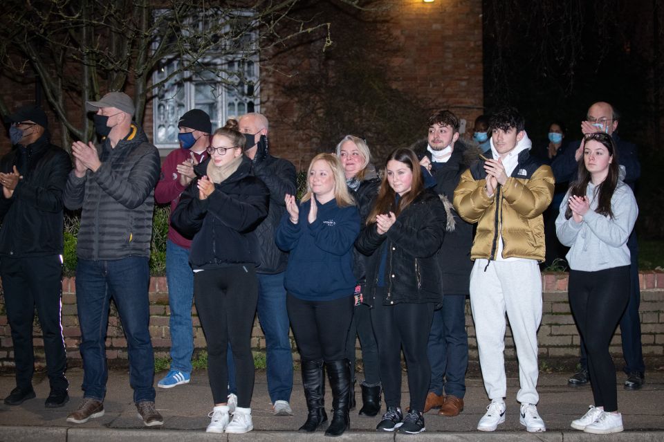 People stand opposite the house of Captain Sir Tom Moore in Marston Moretaine in Bedforshire to pay tribute