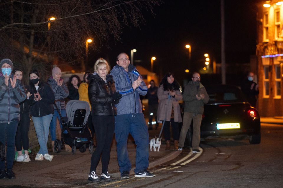 People stand opposite the house of Captain Sir Tom Moore in Marston Moretaine in Bedforshire, to join in with the clap