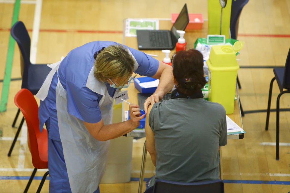 A person receive a dose of the Oxford/AstraZeneca vaccine at a vaccination centre at Cwmbran Stadium in Cwmbran, south Wales.