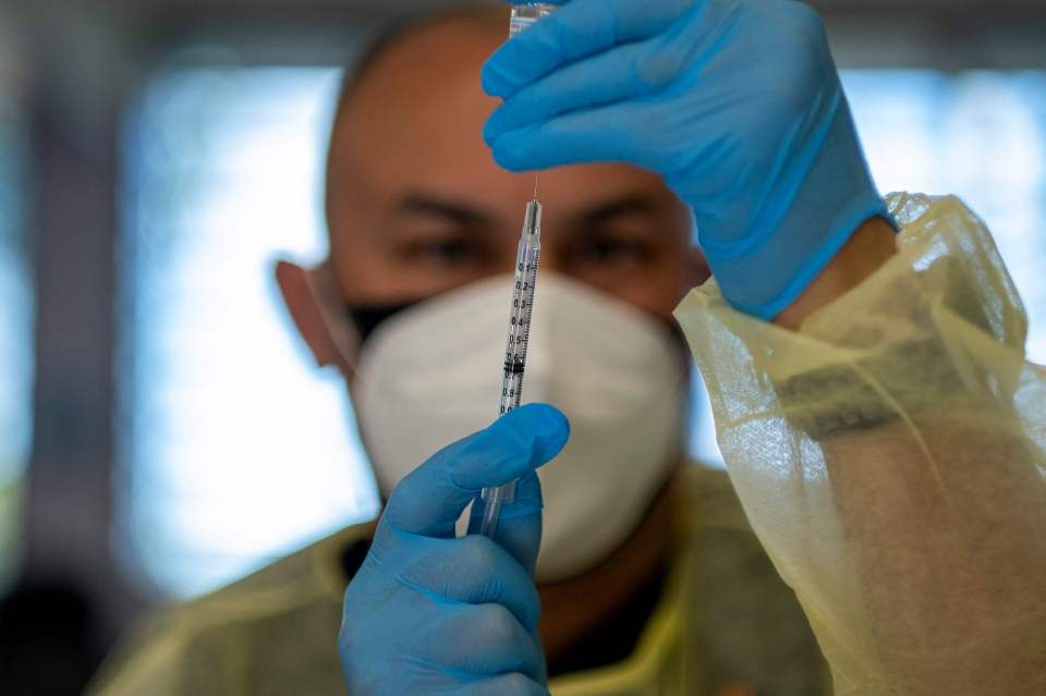 Scientists are confident that vaccines being given in the UK will still protect against the Kent variant - the most dominant one. Pictured: A Royal Navy medics prepares the Oxford/AstraZeneca Covid-19 at a vaccine centre in Bath, southwest England