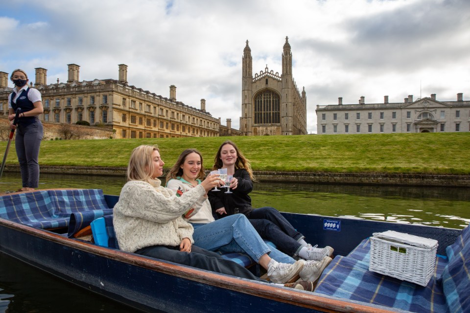 Three friends enjoying a drink on the River Cam in Cambridge