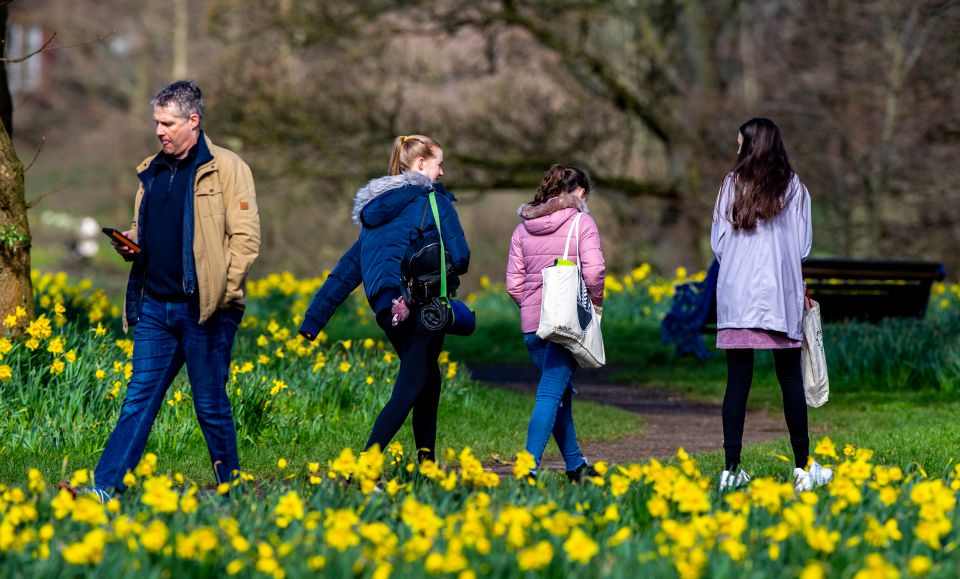 People enjoy a walk in Sefton Park, Liverpool on the first day of the easing of England's lockdown restrictions