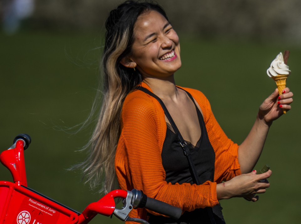 This woman is obviously delighted to be having an ice-cream while enjoying the sun on Hampstead Heath, London