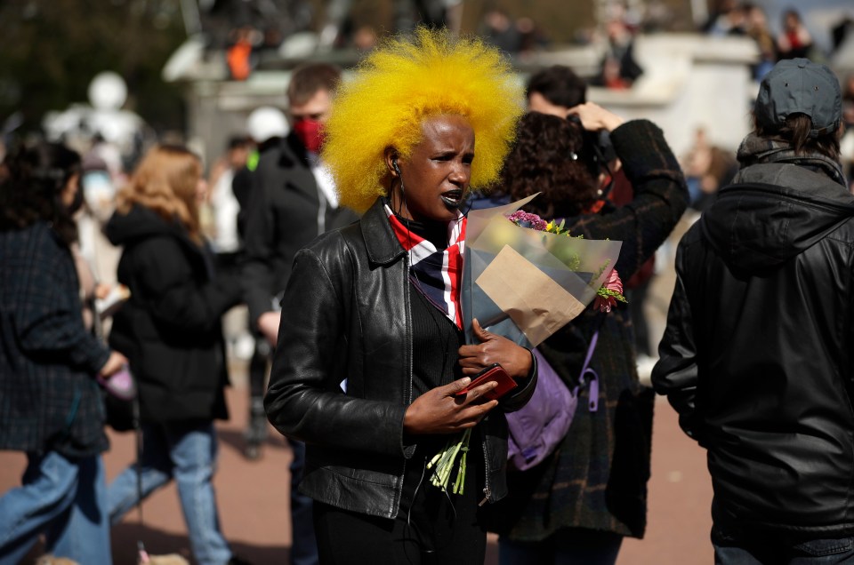 A woman arriving with flowers at Buckingham Palace