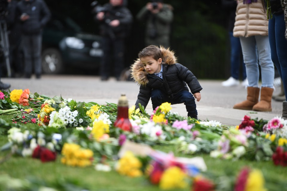 A young girl adds to the sea of flowers outside Windsor Castle
