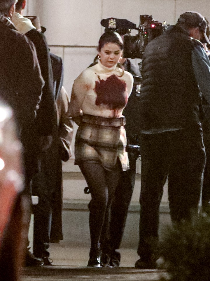 The superstar, 28, was snapped being snatched by cops on set
