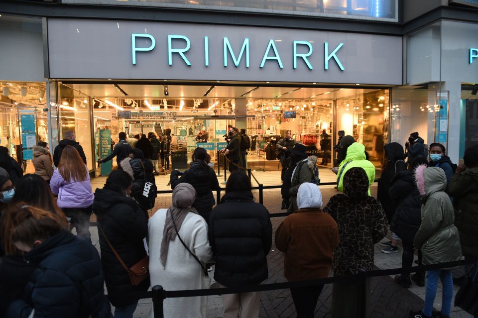 Early morning shoppers stand in line outside Primark, Birmingham, waiting for the store to reopen