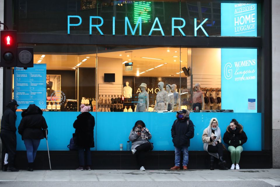 Early morning shoppers stand in line outside the Primark store in Oxford Street
