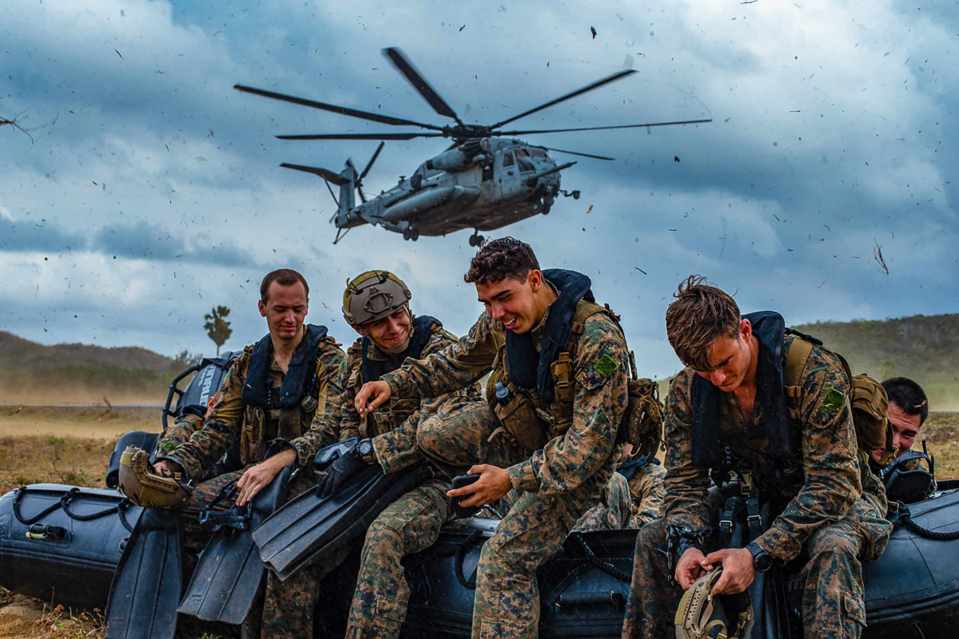 Marines with the 31st Marine Expeditionary Unit's Maritime Raid Force laugh and joke with each other while they hold down a combat rubber raiding craft