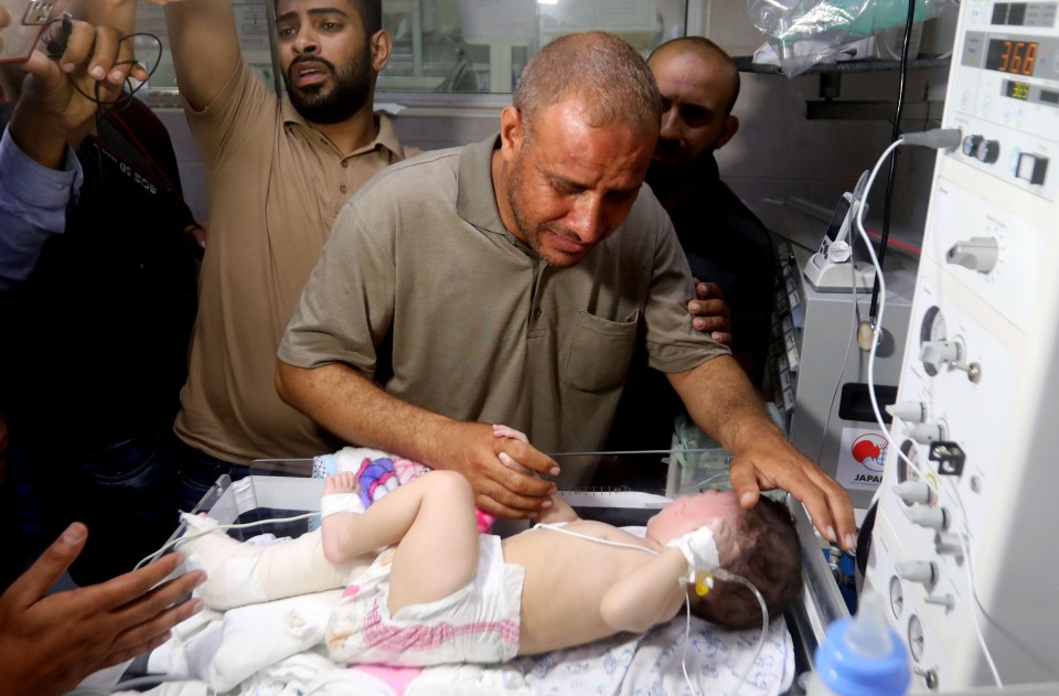 Mohammed al-Hadidi holds his baby who was pulled alive from under rubble