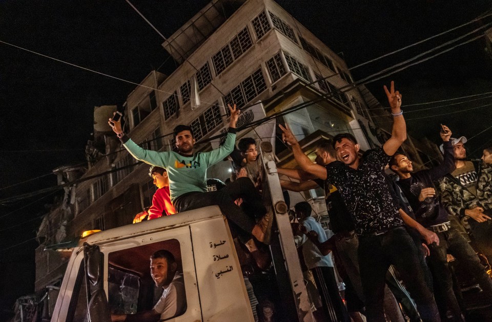 Palestinians celebrate the cease-fire agreement between Israel and Hamas on May 21, in Gaza