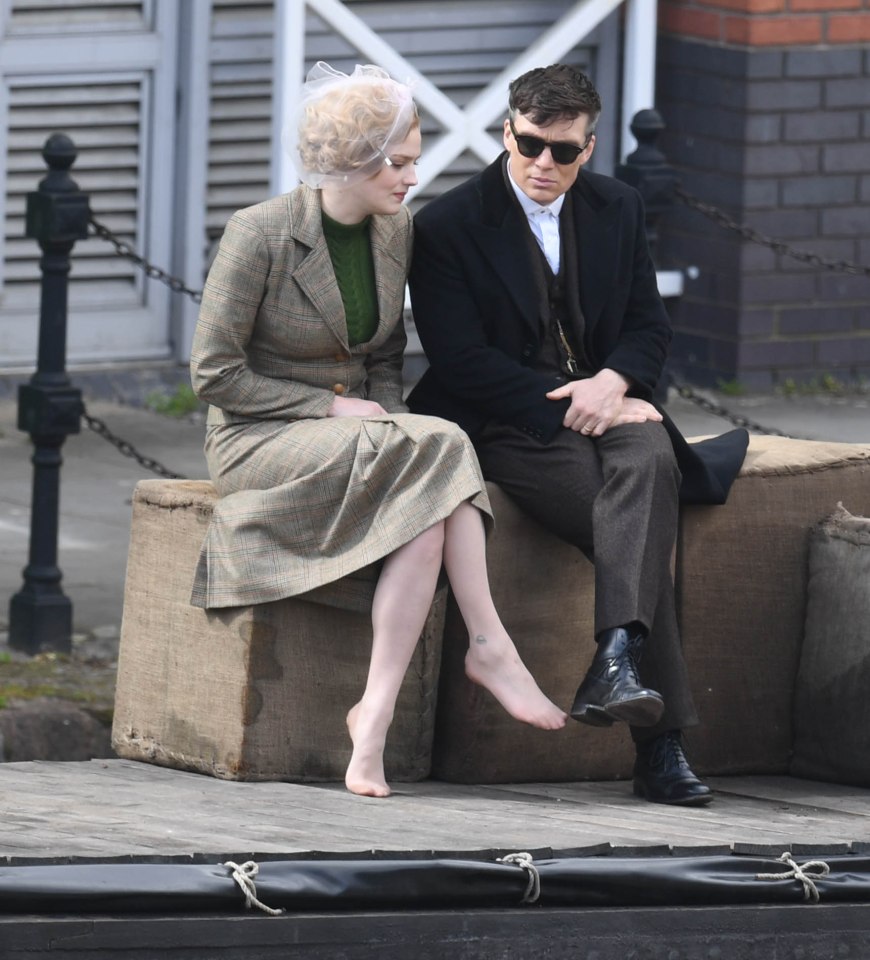 Cillian looked stylish in a long black coat, brown trousers and smart shoes