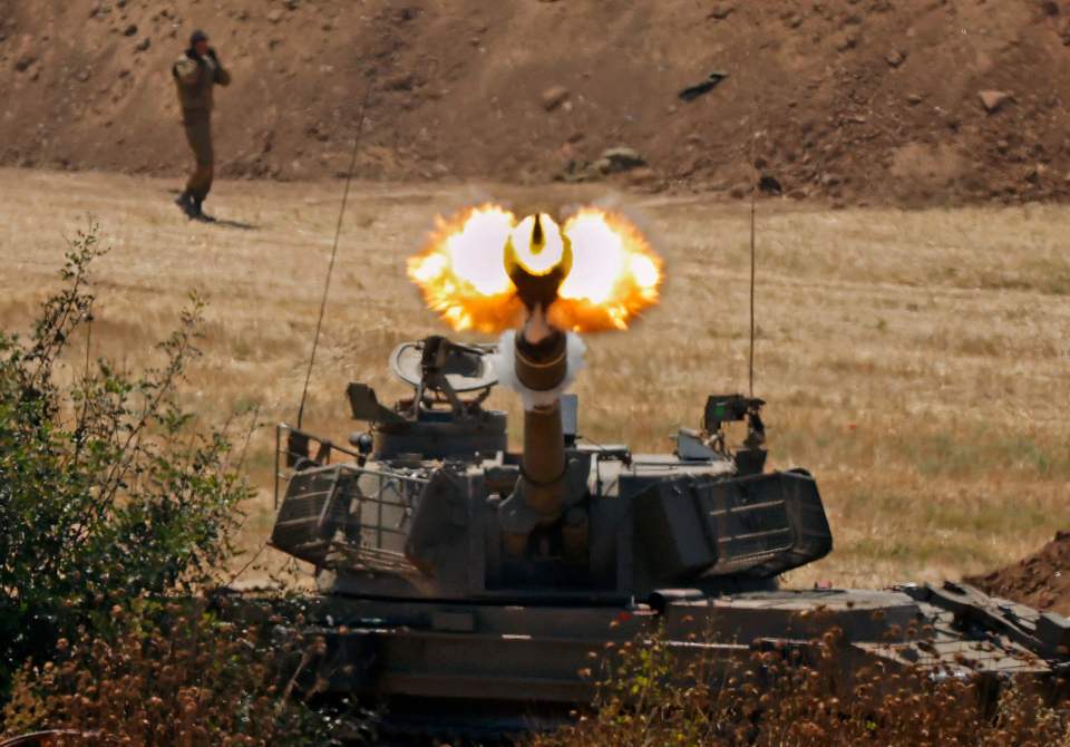 Israeli soldiers fire a 155mm self-propelled howitzer towards the Gaza Strip
